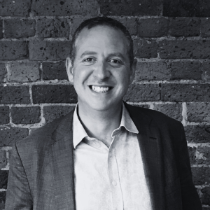 David Moran stands in front of a brick wall smiling