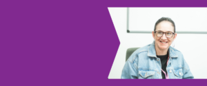Purple background with an image of a smiling lady wearing glasses and a denim jacket.