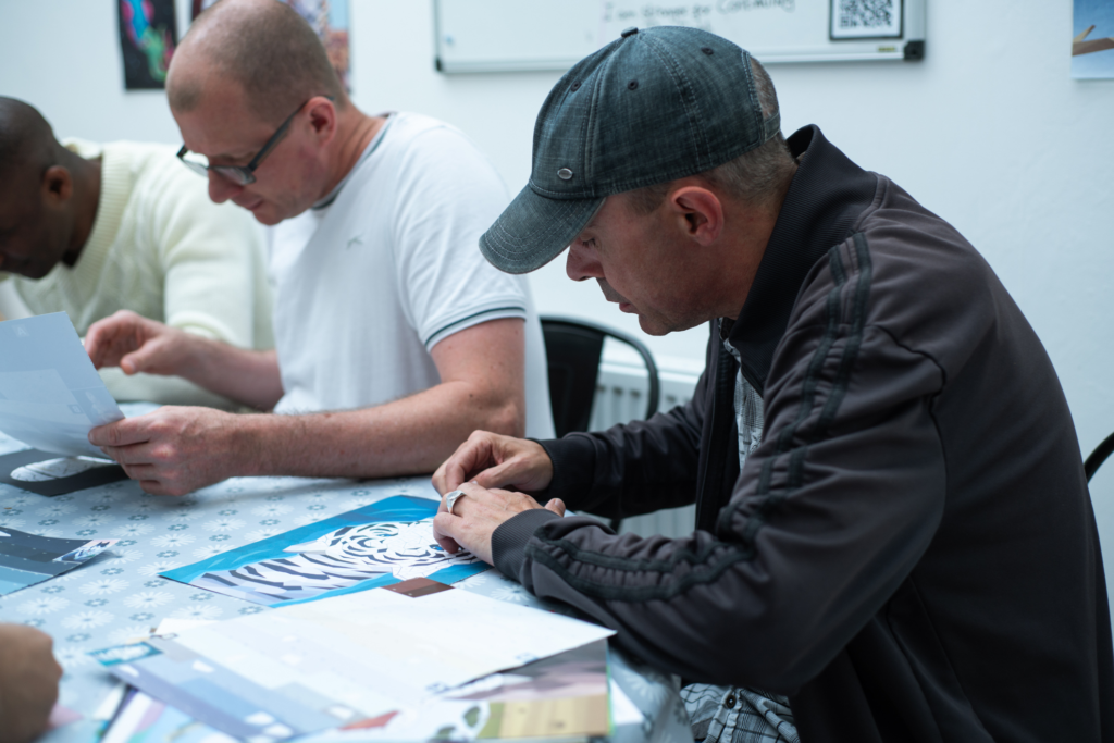 A man wears a hat and is journalling